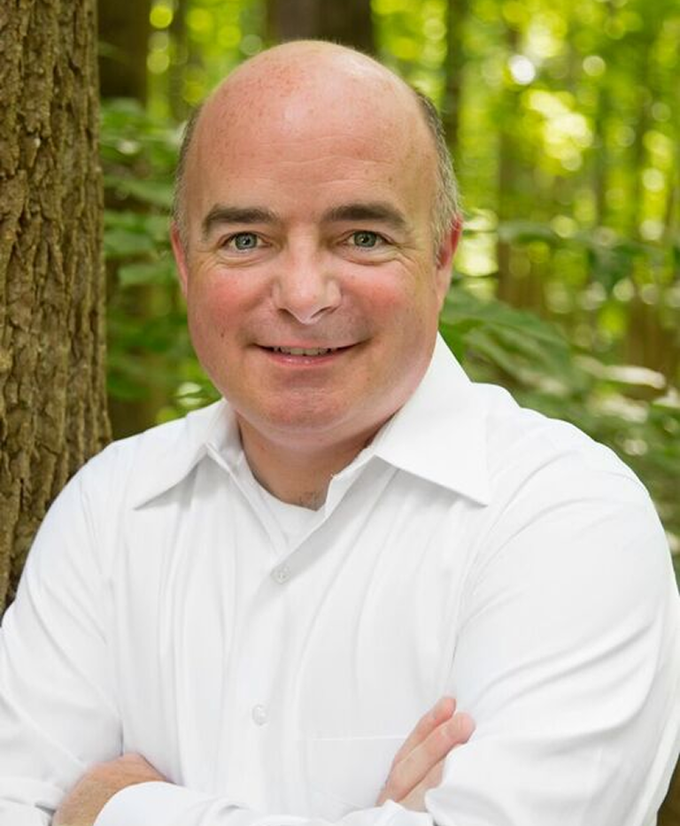 Smiling bald man in white shirt outdoors